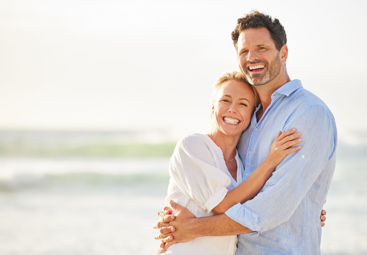 A happy couple embracing on the beach